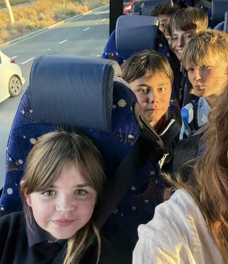Students seated in a coach ready to leave on excursion.
