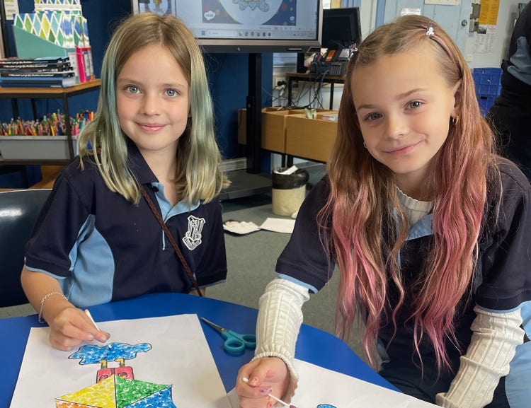 Two students creating colourful dot paintings using cotton buds.